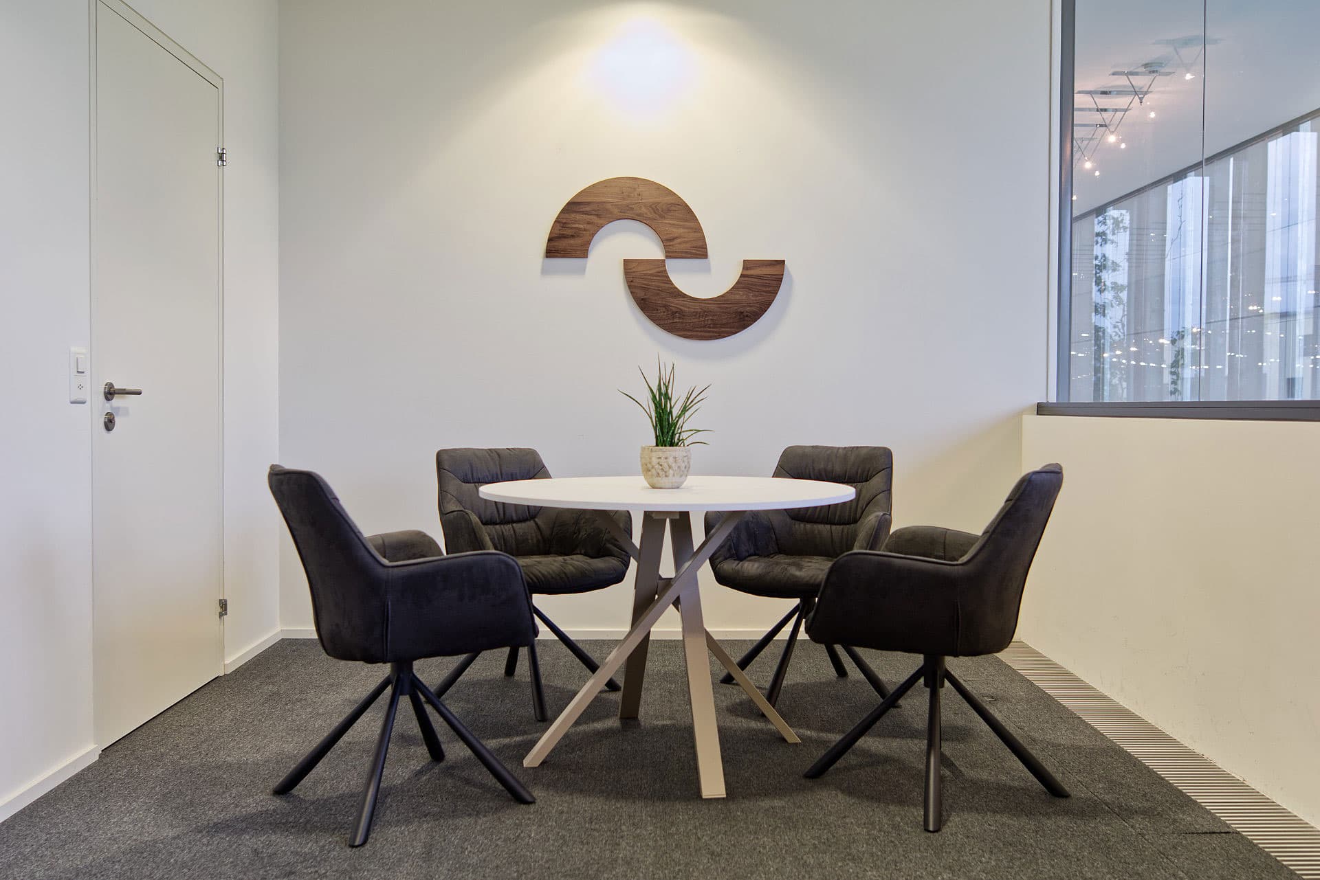 Büro von okto mit in Holz geschnittenem Logo